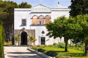 库特罗菲安诺Critabianca - Masseria in Salento的前面有一棵树的白色房子