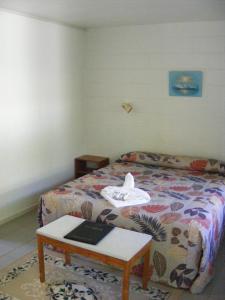 拉罗汤加森特尔汽车旅馆的一间卧室配有一张床和一张桌子,上面有一本书