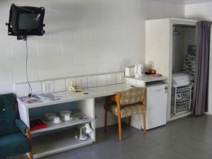 拉罗汤加森特尔汽车旅馆的一间带书桌和冰箱的小厨房