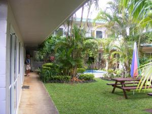 拉罗汤加森特尔汽车旅馆的一个带野餐桌和棕榈树的房子的门廊