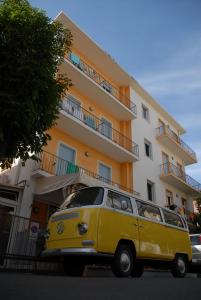 里米尼Jammin' Hostel & Bar Rimini的停在大楼前的黄色货车