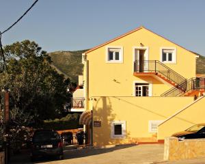 察夫塔特巴坎服务公寓酒店的一座黄色的房子,前面有一辆汽车