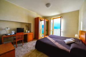 佩尔莱多科奥托迪吉娜酒店的一间卧室配有一张床、一张书桌和一台电视