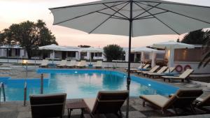 斯基罗斯岛美丽卡利酒店的一个带椅子和遮阳伞的大型游泳池