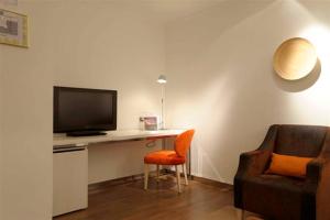 巴尔巴斯特罗索蒙塔诺圣雷蒙酒店的客厅配有书桌、电视和椅子