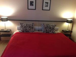 久洛Albatrosz Apartman的一间卧室配有一张红色的床和两盏灯