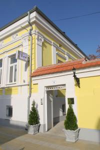 波扎雷瓦茨Konak的一座黄色和白色的建筑,前面有两棵树