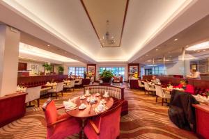 约翰内斯堡City Lodge Hotel Sandton, Morningside的一间设有红色椅子和桌子的餐厅,以及供吃的人用餐