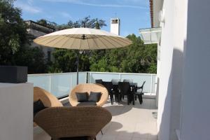 阿尔勒布朗希公寓的庭院配有桌椅和遮阳伞。