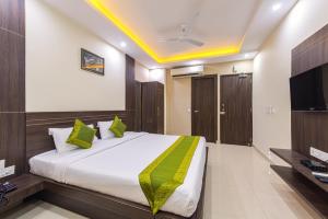 加尔各答Treebo Trend Globe International的一间卧室配有一张大床和电视