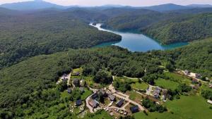 普利特维采村Ethno Houses Plitvice Lakes Hotel的享有房子和湖泊的空中景致