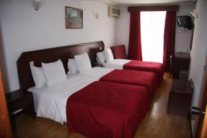 米兰达·杜·杜罗米兰达图里斯莫酒店的酒店客房带两张床和一张红色沙发