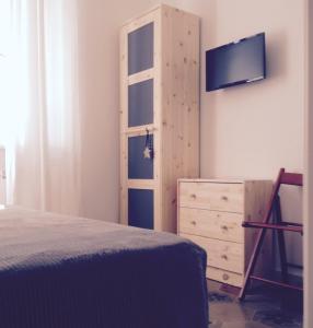 马里纳迪马萨B&B Giù le Stelle的一间卧室配有一张床、一台电视和一个梳妆台