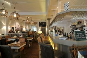 韦斯特兰奥思咖啡厅旅馆的餐厅设有酒吧和桌椅