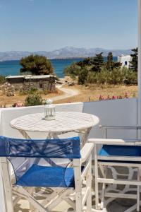 德里奥斯塔萨公寓酒店的阳台上配有白色的桌椅,享有海景