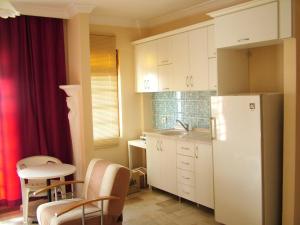 库萨达斯古尔泰佩公寓酒店的厨房配有冰箱和桌椅