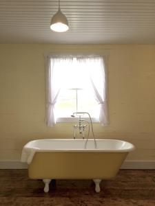 GreenspondThe Old Salt Box Co. - Aunt Christi's的窗户客房内的浴缸