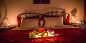卡托劳塔翁多西亚酒店的床上的水果盘和一杯葡萄酒