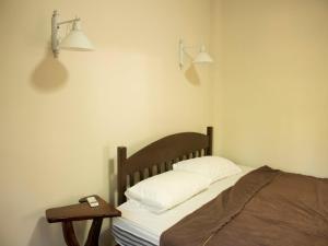 哈林海滩丛林健身房和生态旅馆的一间卧室配有一张床和一张边桌