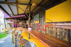 鹅銮鼻墾丁戀戀莎堡特色民宿 Castillo的黄色墙前带凳子的酒吧