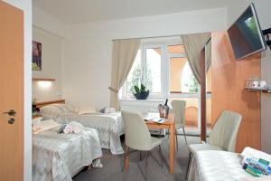 布拉格布拉格葡萄酒旅馆的一间设有两张床和一张桌子及椅子的房间