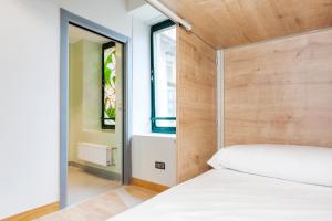 圣塞瓦斯蒂安A Room In The City Hostel的卧室配有白色的床和木制床头板