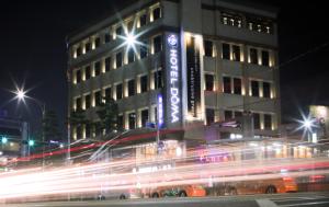 首尔明洞多玛酒店的一座在晚上有一辆公共汽车在前面的建筑