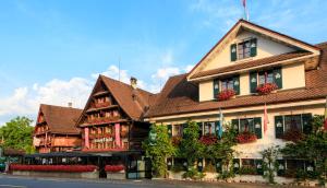 屈斯纳赫特Swiss-Chalet Merlischachen - Historik Chalet-Hotel Lodge的一座大建筑前面有鲜花