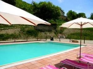 斯波莱托APPARTAMENTI Villa Marianna的一个带两把遮阳伞和两把椅子的游泳池