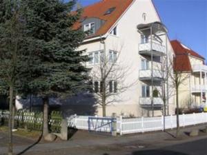奥斯赛拜-屈隆斯博恩Appartementhaus Ulmenhof的前面有一棵树的白色大建筑