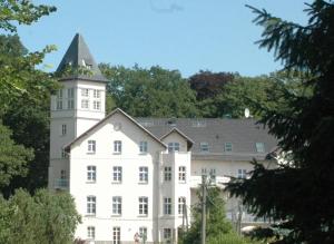 霍恩宁多夫Appartement Schloß - Hohen Niendorf的一座白色的建筑,上面有一座塔