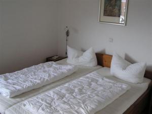 奥斯赛拜-屈隆斯博恩Appartementhaus Gegenkolonnaden的一张带白色床单和枕头的床