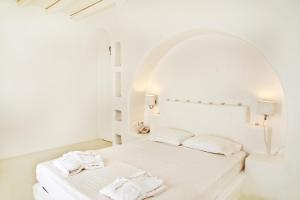 提诺斯阿尔塔纳精品酒店的白色卧室配有带2条毛巾的床