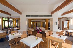 吉奥弗特尔奥维墨林酒店的餐厅设有白色的桌椅和窗户。