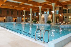 比尔什托纳斯比尔什托纳斯云杉SPA疗养度假村的一座大型游泳池,在一座建筑中设有喷泉