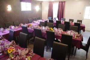维舍LOGIS-Hôtel Restaurant Auberge Les Vallées Du Perche的配有桌椅和紫色桌布的房间