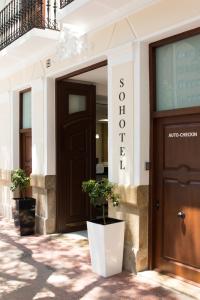 瓦伦西亚巴伦西亚索霍公寓式酒店的一座有门的建筑,前面有植物