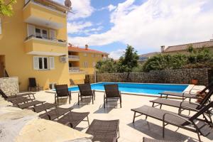 巴斯卡Apartments Gorica 2的一个带椅子的庭院和一个游泳池