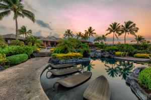 瓦克拉Castle Hali'i Kai at Waikoloa的一个带椅子和棕榈树的游泳池的度假酒店