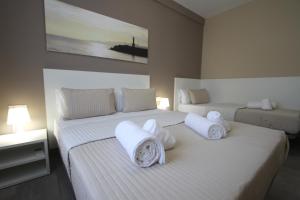 坎布里尔斯Apartamentos Cambrils Playa Spa的卧室内的两张床,配有白色床单和枕头
