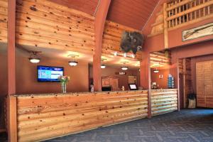 佩森科尔牧场钻石山林小屋的大堂设有大型木墙和酒吧