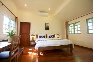 湄林麒麟星座度假村的卧室配有一张床、一张书桌和窗户。