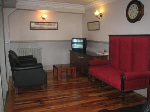 昆卡卡诺瓦斯旅馆的客厅配有红色沙发和电视