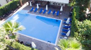 卢特拉伊帕蒂斯埃纳酒店的享有带椅子和遮阳伞的游泳池的上方景色