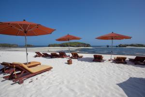 瓦塔穆Seven Islands Resort的海滩上的一组椅子和遮阳伞