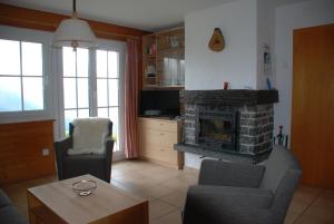 贝特默阿尔卑Chalet Foresta的客厅配有两把椅子和壁炉