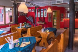 泰奥尔Ristorante Albergo Al Donatore的餐厅设有木桌和椅子,拥有红色的墙壁