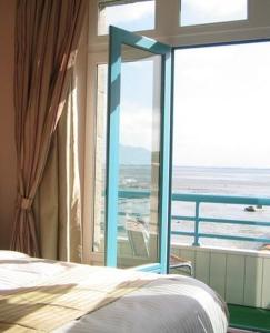 康卡勒米尔山普伦酒店的一间卧室设有一张床和一个大窗户