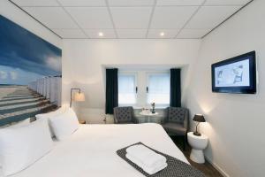 登堡斯暮尔博特精品酒店的一间卧室配有一张床、一张桌子和一台电视