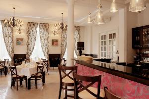 赞布鲁夫Impresja Restauracja Hotel的餐厅设有酒吧,配有桌椅